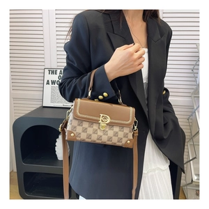 Gros plan du sac vintage avec boucle dorée en D et texture de toile à monogramme