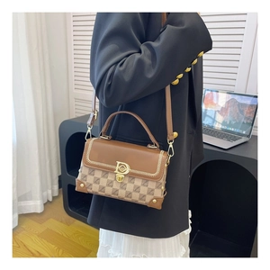 Détail du sac à main vintage avec garniture en cuir brun et boucle en D en métal doré