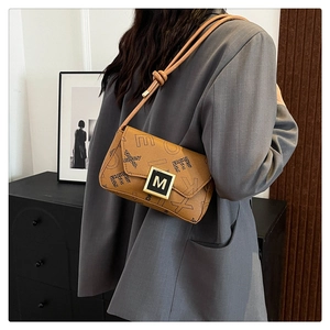 Detail of a brown leather shoulder bag with letter print and knot strap design