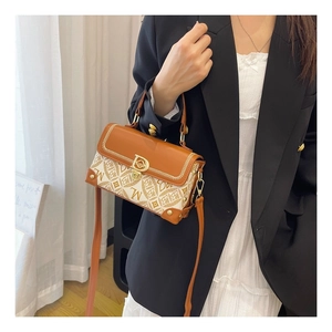 Détail d'un sac à main vintage avec bords en cuir tressé et boucle en métal doré
