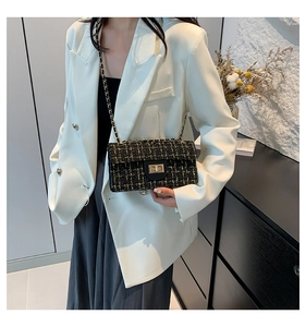 Sac bandoulière en tweed avec fermoir doré et bandoulière chaîne porté par un mannequin