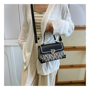 Détail du sac bandoulière vintage avec boucle en D en métal et rabat en cuir noir