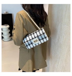 Détail du sac à bandoulière en tweed avec chaîne dorée et fermoir pivotant sur modèle