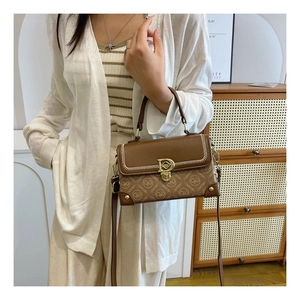 Vue latérale d'un sac à main rétro marron avec boucle D et coutures tressées