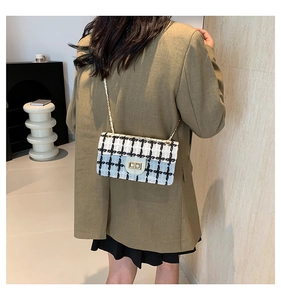 Détail du sac à bandoulière en tweed noir et blanc avec chaîne dorée sur mannequin