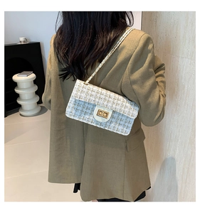 Sac bandoulière en tweed crème avec chaîne dorée et fermoir en métal sur modèle