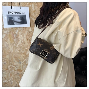 Macro detail of vintage brown printed crossbody bag with metal M buckle on trench coat