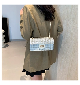 Détail de la texture en tweed à carreaux et du fermoir doré de la bandoulière