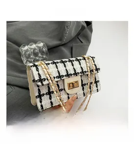 Détail du sac en tweed à motif pied-de-poule noir et blanc avec fermoir doré et chaîne
