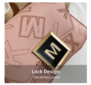 Close-up of pink pebbled leather shoulder bag with golden M logo metal clasp design