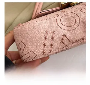 Close-up of pink leather handbag with premium embroidery stitching and metal lock