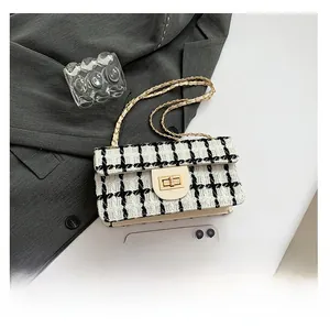 Vue détaillée du sac en tweed noir et blanc avec fermoir doré et bandoulière de chaîne