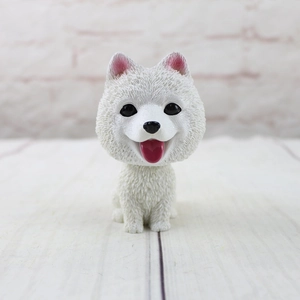 Close-up of cute Samoyed resin car ornament with detailed fur texture and happy expression