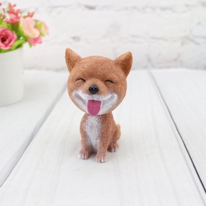 Close-up of resin Shiba Inu car ornament with detailed fur texture and smiling face