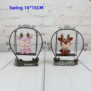 Detail of pink and brown resin deer on a metal swing with a stone base marked FOREST