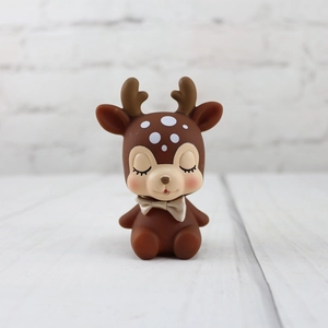 Close-up of cute cartoon deer figurine with closed eyes and pink blush for home decor