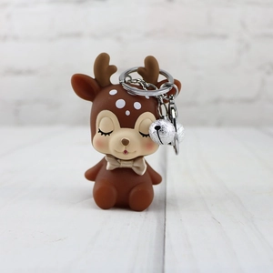 Detail of dark brown deer keychain with silver bells and champagne gold bow tie