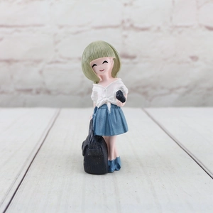 Detail of cute resin girl figurine with green hair and blue pleated skirt for home decor
