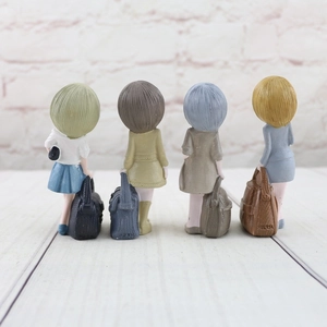 Detail view of four resin girl figurines showcasing intricate hair textures and outfits