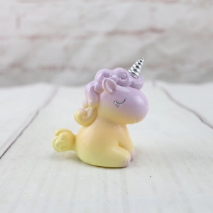 Primer plano detallado de una figura de unicornio en degradado amarillo y morado con cuerno