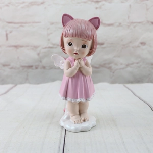 Close-up of pink resin angel girl cake topper with cat ears and white cloud base stand