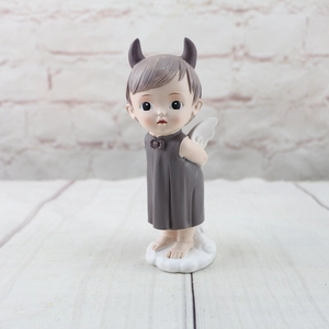 Detailed view of resin angel boy figurine with brown horns on a cloud base
