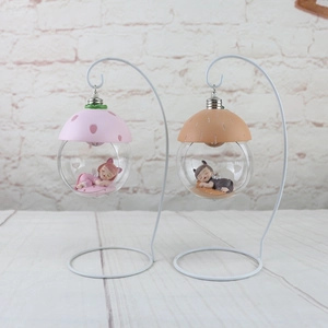 Detail of hanging dream angel figurines in glass globes with metal stands for decor