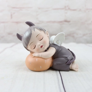 Macro detail of a sleeping baby angel resin figurine with purple horns and wings