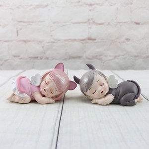 Detail of pink and grey resin sleeping baby angel figurines for cake toppers or gifts
