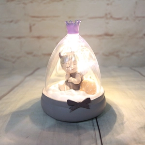 Detail of glowing crown night light with sleeping girl doll and warm LED lighting decoration