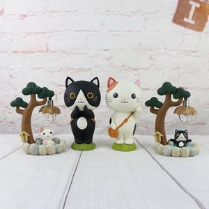 Detailed view of cat night light ornaments and miniature garden figurines on a base