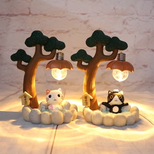 Detail of creative resin cat night light with warm Edison bulb and stone-textured base
