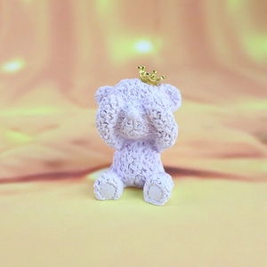 Detailed view of purple bear figurine with rose textures and a golden crown ornament