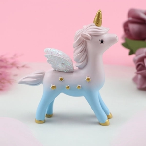Detail of gradient unicorn figurine with golden horn and shimmering glitter wings