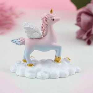 Macro detail of unicorn cake topper with glitter wings and fluffy cloud base