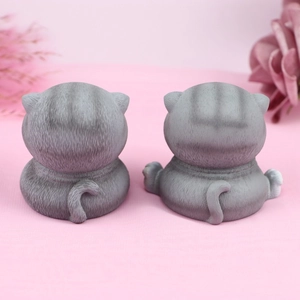 Detailed back view of grey tabby cat figurines with realistic fur texture and curved tails