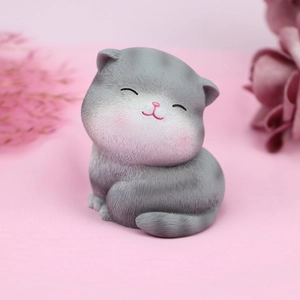 Close-up of a grey resin cat figurine with textured fur and a peaceful smile