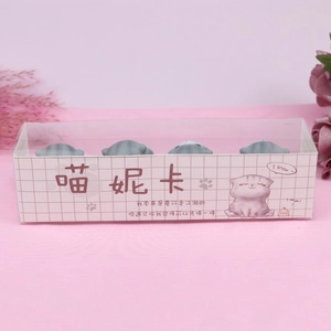 Close-up of 4 grey cat figurines in pink grid box for car decor and cake toppers
