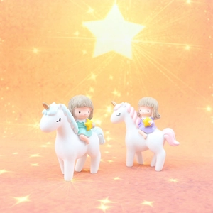 Detail of cute resin unicorn girl figurines with stars for cake or car decor