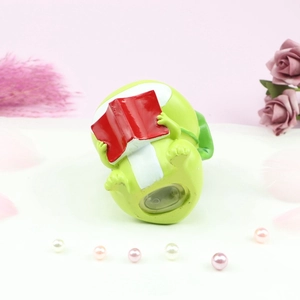 Detail view of the green frog money box base with a secure plastic stopper for coin removal