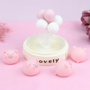 Detailed view of four pink cartoon pigs in a bamboo steamer with balloon decorations