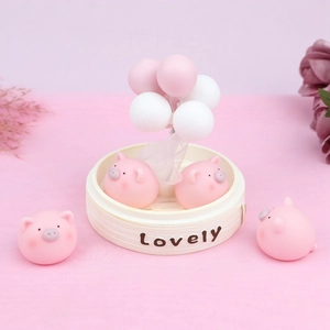Detail of pink pig figurines in a lovely bamboo steamer base with balloon decor