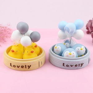 Macro shot of cute chicken and penguin figurines in mini bamboo steamers with balloons