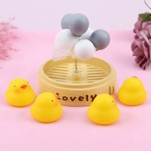 Detail of four yellow miniature ducks with a mini steam basket and balloon cluster decoration