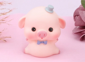 Macro view of cute pink pig ornament with blue bow tie and grey mini hat decoration