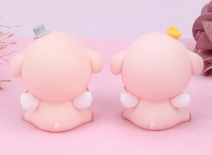 Rear view of cute pink pig cake toppers with wings, crown, and hat on pink velvet
