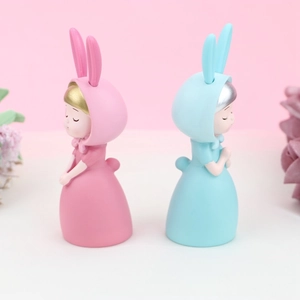 Détail de figurines de filles lapins rose et bleu pour décoration de gâteau et fleurs