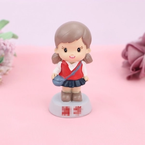 Cute student girl figurine cake topper on pink background with flowers for birthdays