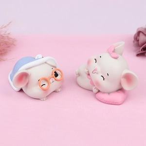 Détails de figurines de souris et lapin en résine sur un fond en tissu rose texturé