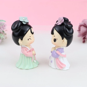 Close-up of two Q-version resin princess figurines for cake decoration with hanfu details